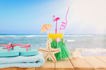 image of tropical and exotic fruit coctail over wooden table infront of sea landscape background