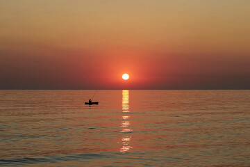 fisherman in boat in Caspian Sea in sunrise