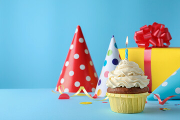 Delicious birthday cupcake with candle on light blue background, space for text
