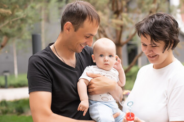 Happy family: mother father and child on nature