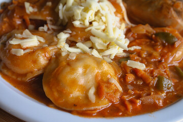 Homemade stuffed pasta bathed with tomato sauce and grated cheese.