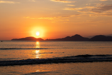 praia com pôr-do-sol no verão