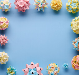 Set of multicolor handmade modular origami balls or Kusudama Isolated on blue background. Visual...
