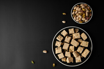 Organic halva with pistachios on black background. Traditional middle eastern sweets. Jewish,...
