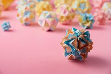 Set of multicolor handmade modular origami balls or Kusudama Isolated on pink background. Visual...