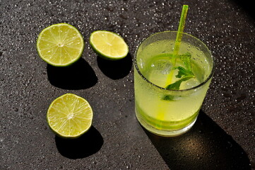 Natural juice with ice and lime on a black background.