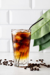 Cold drink with espresso and tonic in glass on white background, vertical