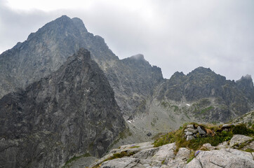 Jagged and sharp ridges rock emerge from the mist above and rain clouds at High Tatras National Park, Slovakia