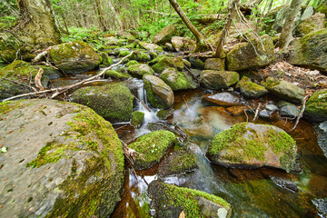 Small river of waterfalls through mossy rocks
