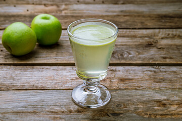 green Apple juice on glass on old wooden table