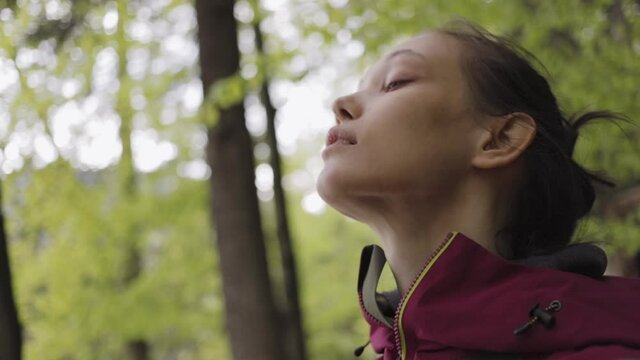 Woman breathes fresh air in a mountain forest.