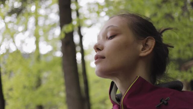 Woman breathes fresh air in a mountain forest.