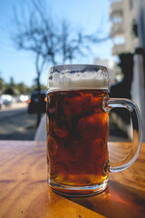 Glass of beer ('beer shop') in a table in a sunny day