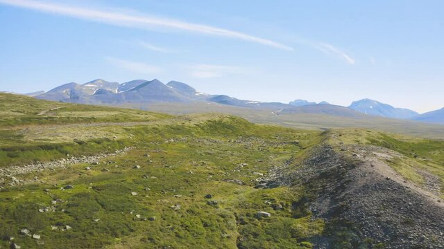 Rocky Green Fields With Mountains And Blue Sky In The Background In Rondane National Park, Norway. - aerial
