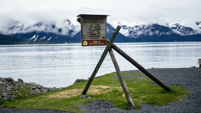 Seward to Nome milestone board on wooden planks on a coast
