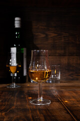 Glasses of strong scotch single malt whisky served on dark wooden table in old pub