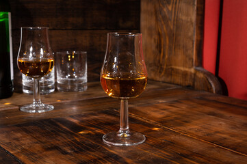 Glasses of strong scotch single malt whisky served on dark wooden table in old pub