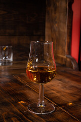 Glasses of strong scotch single malt whisky served on dark wooden table in old pub