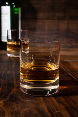 Glasses of strong scotch single malt whisky served on dark wooden table in old pub