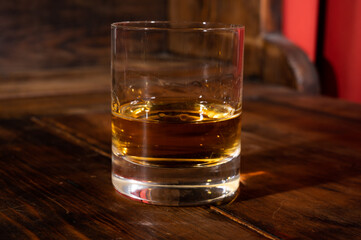 Glasses of strong scotch single malt whisky served on dark wooden table in old pub