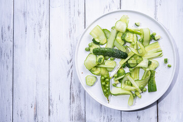 Summer green pea salad of cucumbers and pea on a white