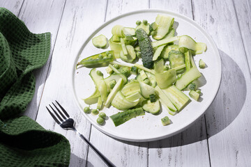 Summer green pea salad of cucumbers and pea on a white