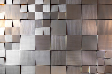 square gold tiles on the wall. rough surface texture