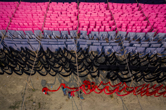 Aerial view of workers hanging thousands of meters of different coloured t-shirt fabrics to dry in Narayanganj, Dhaka, Bangladesh.