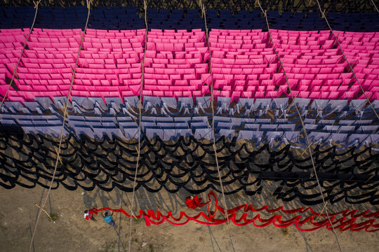 Aerial view of workers hanging thousands of meters of different coloured t-shirt fabrics to dry in Narayanganj, Dhaka, Bangladesh.