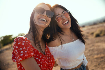 Two smiling young women talking anad laughing while enjoying summer on road trip.