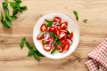 Tomato salad with onion, fresh basil and olive oil, top view