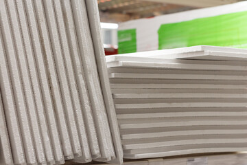 Gray thin extruded polystyrene foam for insulation of floors, facades, plinths, foundations on a shelf in a store.