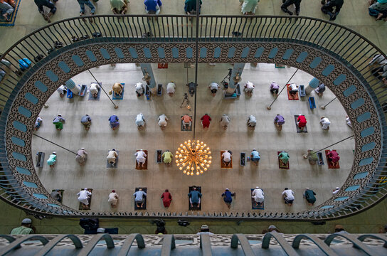 View of many people praying in a big islamic mosque in Dhaka, Bangladesh.