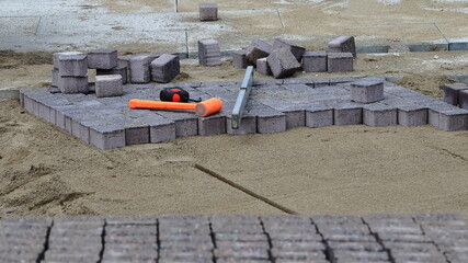 Kostka. Spirit level, hammer, tape measure. Brukarstwo. Laying paving stones © jarizPJ