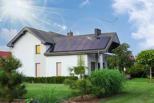 Beautiful house with solar panels. Clear sky an sun. ECO CONCEPT.