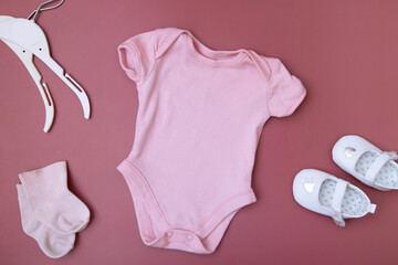 Baby clothes mock up for your text on a pink background with accessories