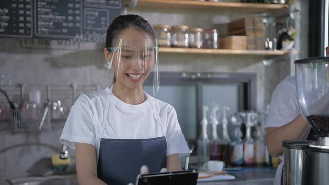 Coffee shop concept of 4k Resolution. Asian female employees are taking orders from customers in the store.