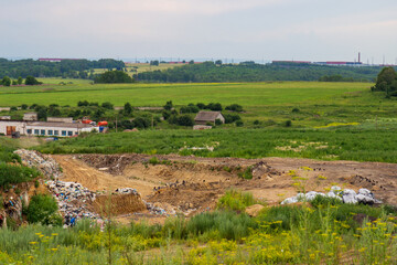 View of waste disposal city site among fields. Environmental pollution of the planet with household waste