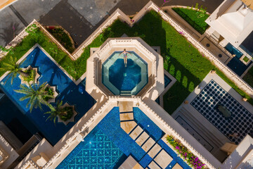 Aerial view of a woman relaxing in a swimming pool in a luxury hotel in India.