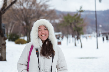 Beautiful and happy young Asia Chinese girl in winter snowy day outdoors - Winter Holiday Concept