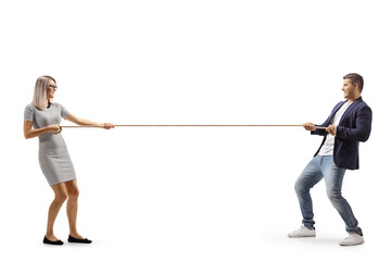 Full length profile shot of a young man and woman pulling a rope