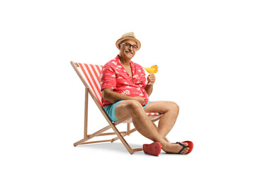 Mature male tourist sitting in a chair with a cocktail