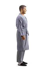 Fototapeta premium Full length profile shot of a young man wearing a robe over pajamas