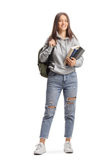 Full length portrait of a female student with a cap holding books and backpack - obrazy, fototapety, plakaty