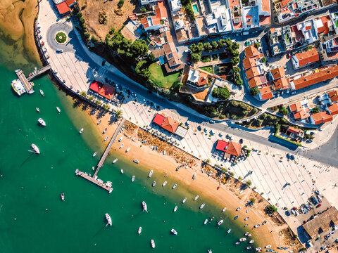 Aerial view of boats anchored at pier at Alvor city port in Ribeira de Odiaxere, Alvor, Algarve region, Portugal.