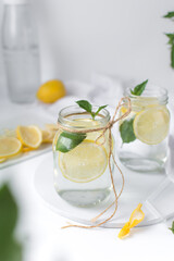 Lemon lime soda in a mason jar with a lemon slice and  basil leaves, lemonade in a glass jar