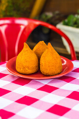 Coxinha, traditional brazilian food. consisting of chopped or shredded chicken meat, covered in dough, molded into a shape resembling a teardrop, battered and fried.