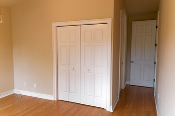 empty neutral colored room room with wood floors and many doors