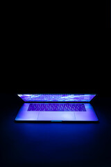 Isolated high tech open laptop with abstract vibrant color screen on a dark background. - obrazy, fototapety, plakaty