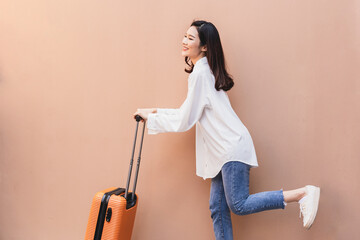 a woman wear fashion clothes going to travel on summer day and drag the suitcase